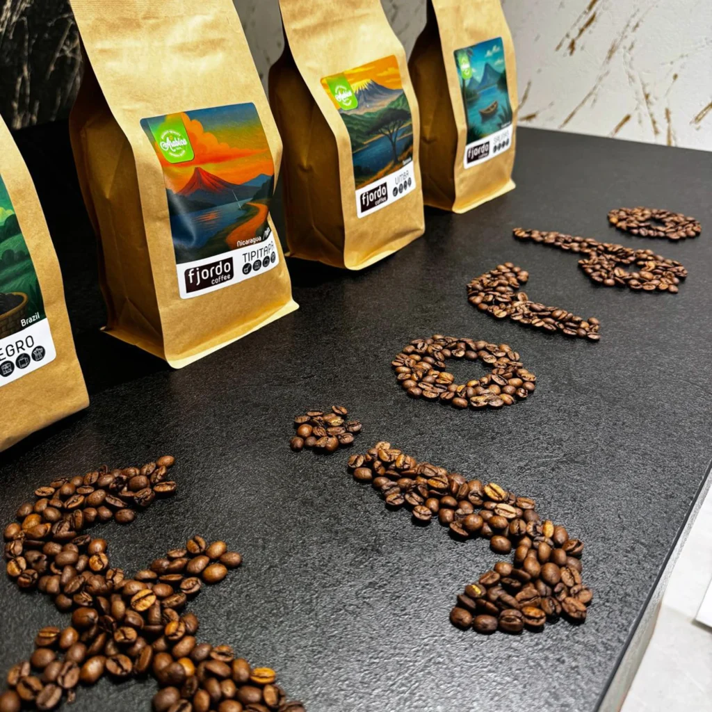 fjordo-sklep-stacjonary-zory-wnetrze-zestaw-kaw-1 Zestaw kaw Fjordo w opakowaniach kraftowych z ziarnami ułożonymi w napis Fjordo na blacie